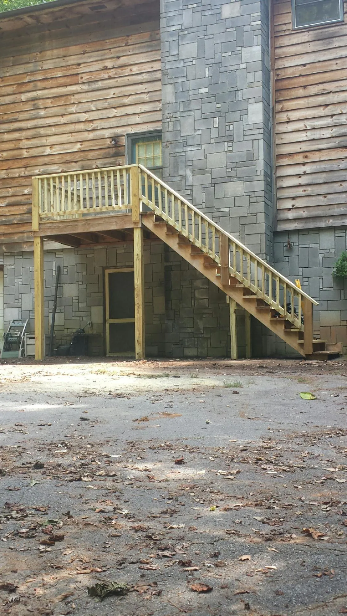 New pressure treated deck and stair landing on a log home in Nordland
